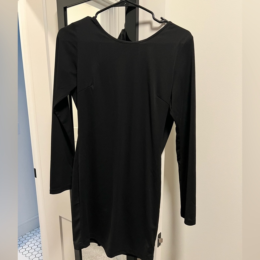 Long sleeve, open back, black mini dress.